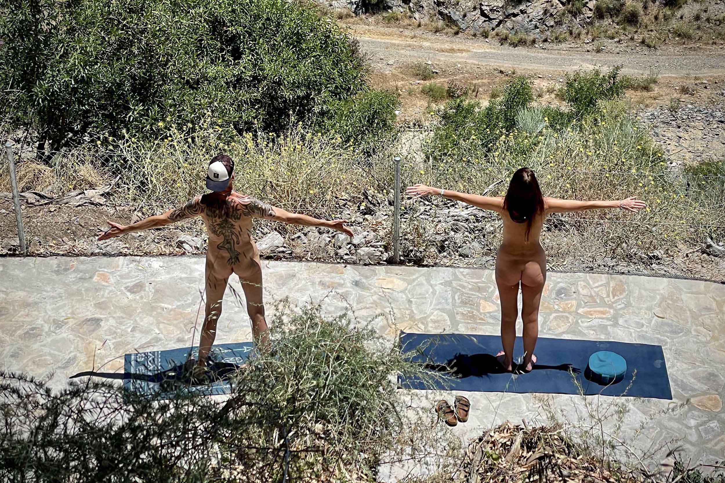 naakte man en vrouw doen yoga op het lage terras